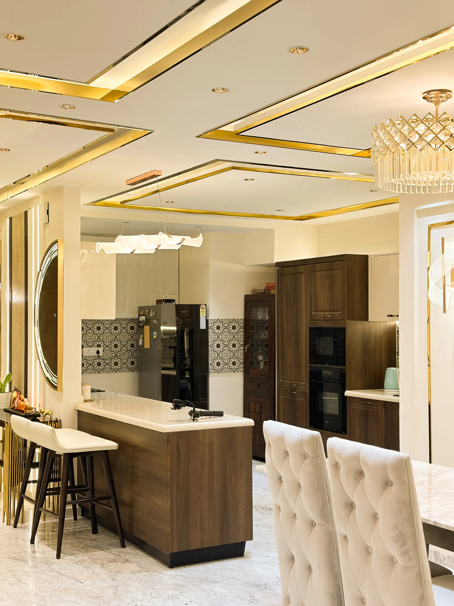 Open kitchen with walnut breakfast counter and gold-trimmed ceiling — Divyarjuna